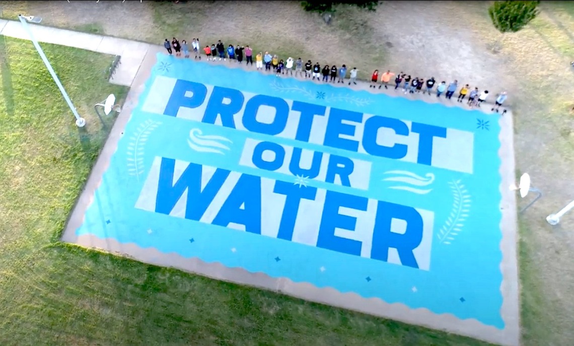 Aerial image of a blue and white banner that reads protect our water