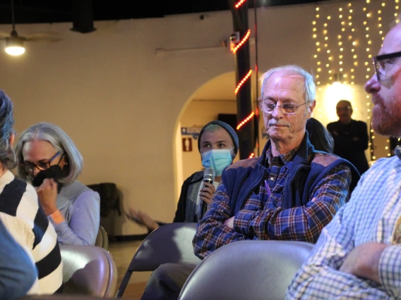 A member of an audience asking a question during a Show & Tell Event.