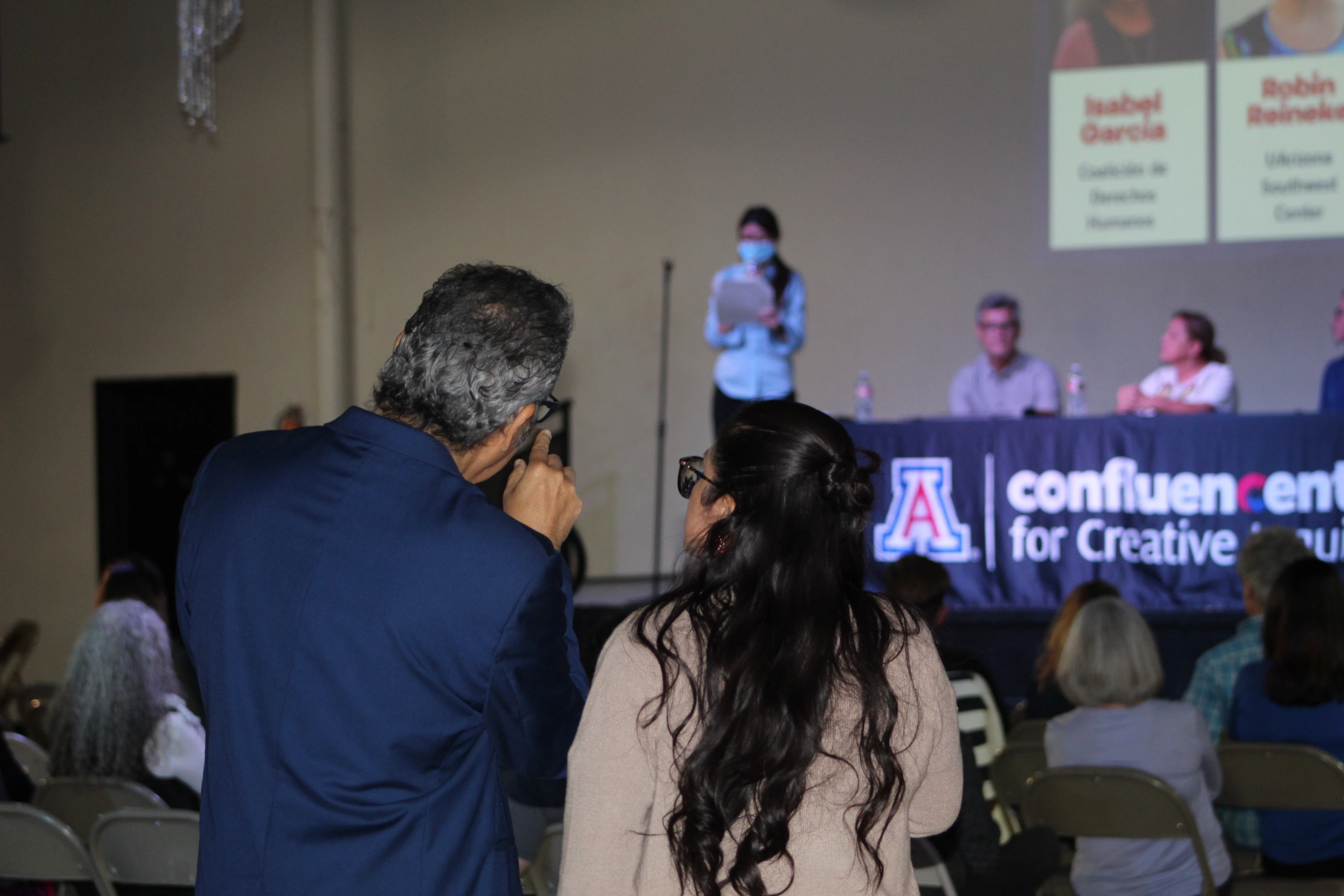 Man and women, over the shoulder, discussing something.