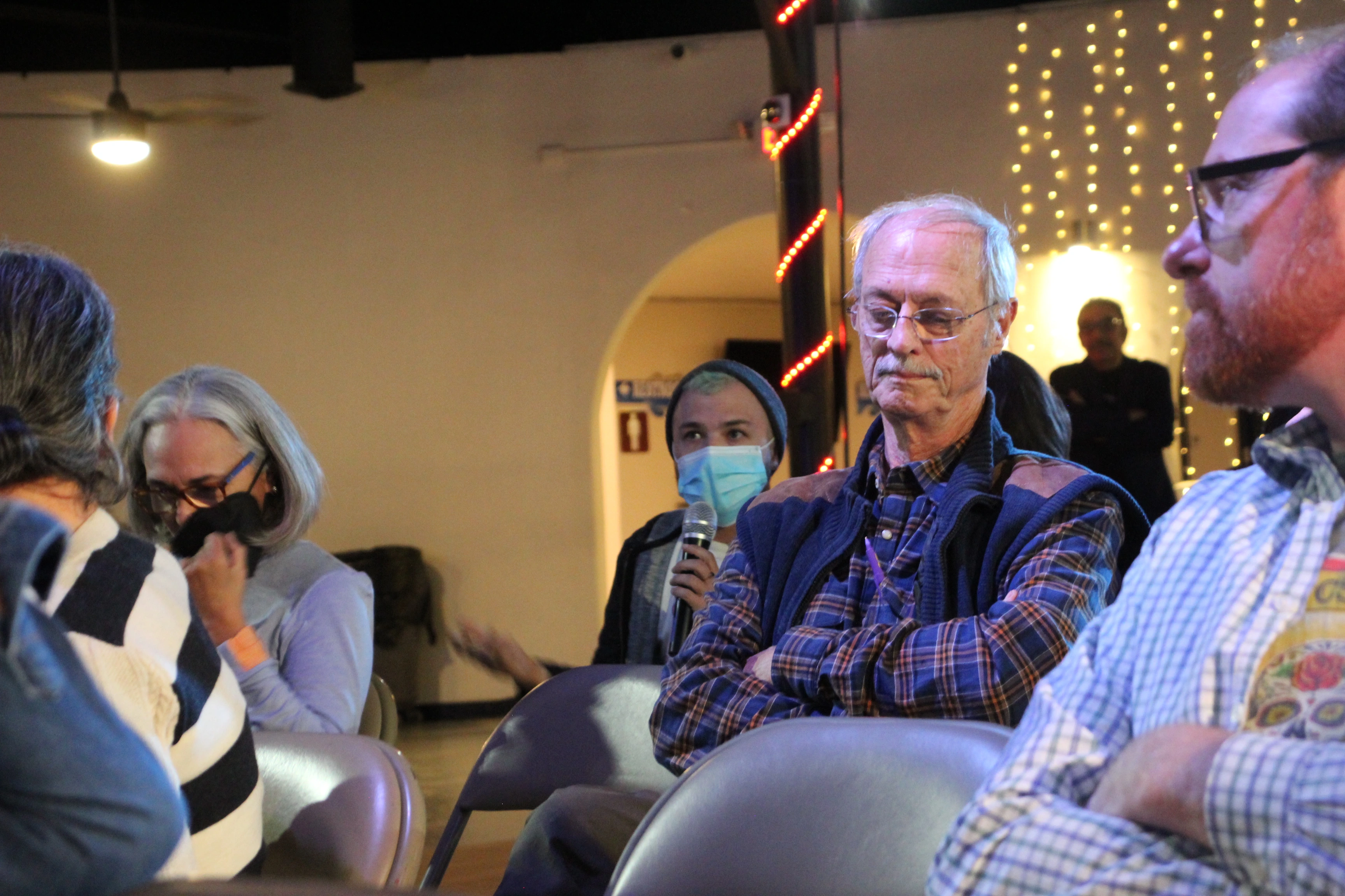 A member of an audience asking a question during a Show & Tell Event.