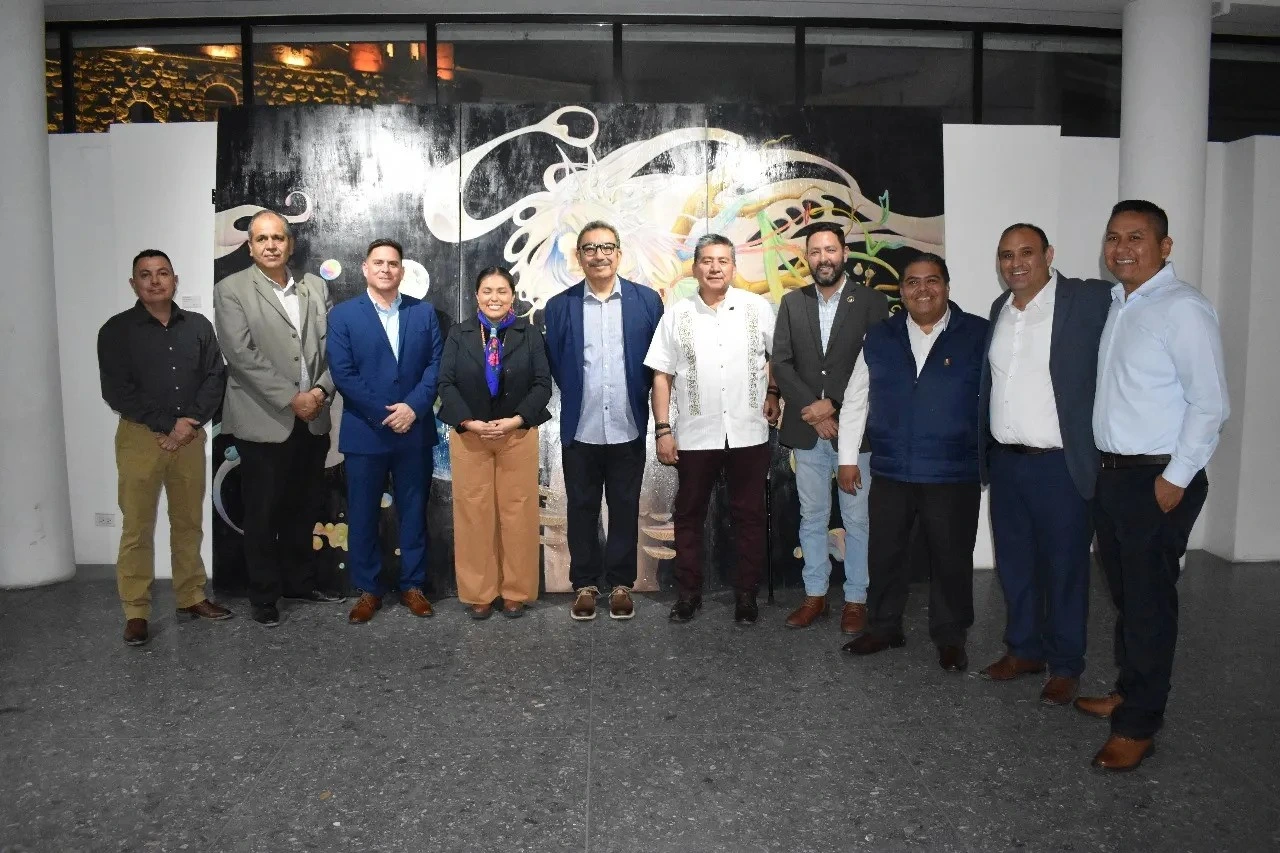 Group of people standing together in front of a art piece